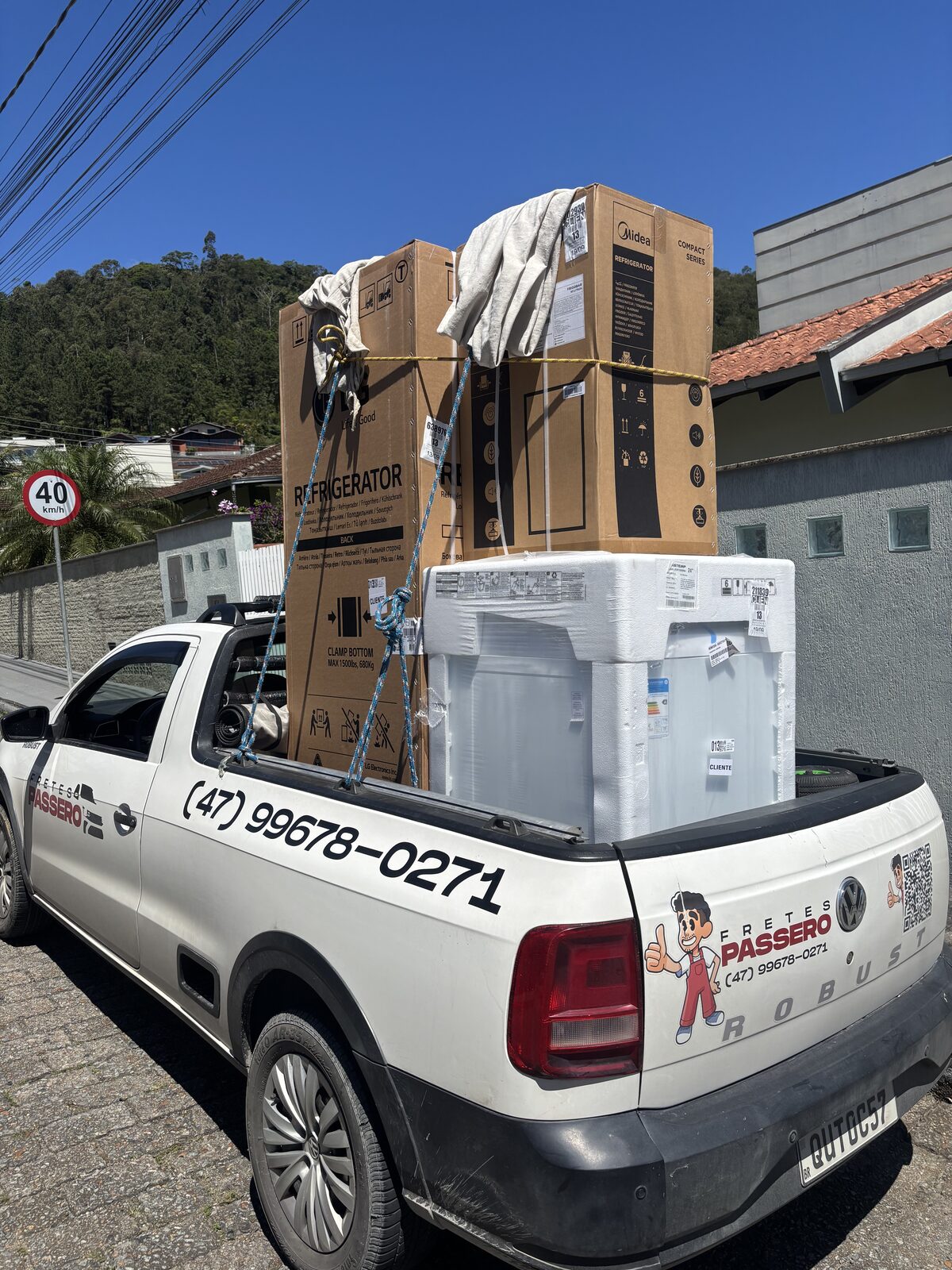 Caminhonete Saveiro da Fretes Passero carregada com geladeiras e fogão prontos para entrega
